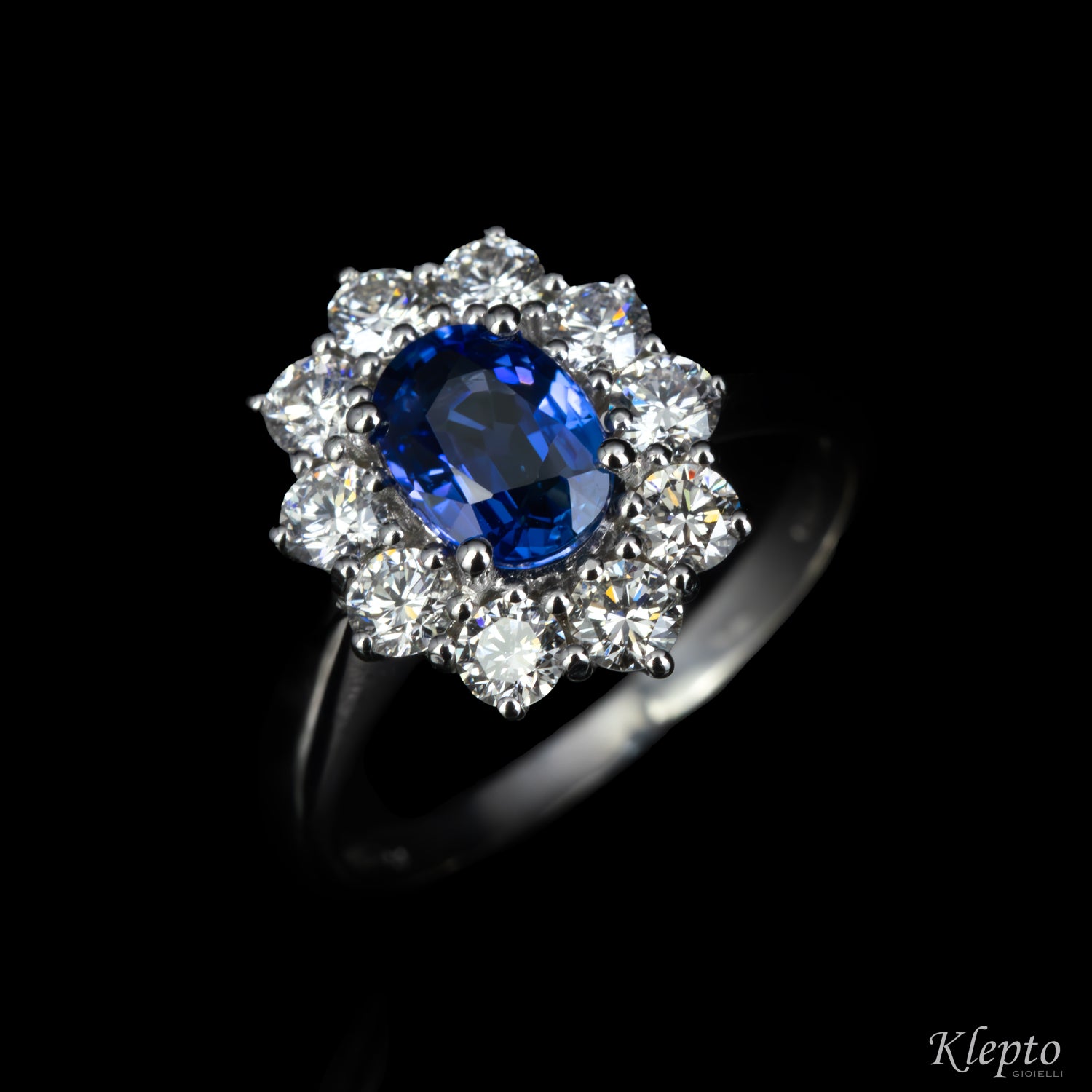 Anello classico in oro bianco con Zaffiro blu e contorno di Diamanti